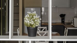 Un interior moderno con una estantería blanca que sostiene tres macetas.