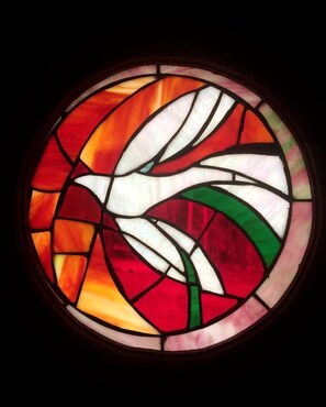 Una vidriera circular con un diseño de paloma blanca.