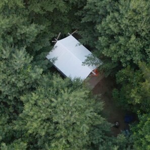 An aerial view of a small, rectangular building surrounded by dense green foliage.