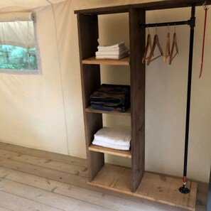A wooden shelf unit with folded towels and hanging items. - Beautiful Ontario Glamping Tent Along Lynn River (Port Dover)