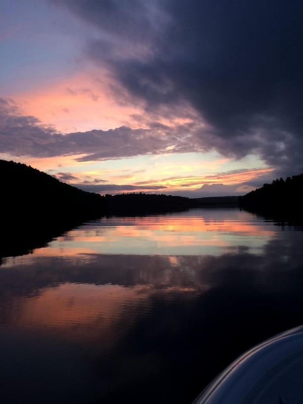 Un llac tranquil que reflecteix un cel al capvespre.