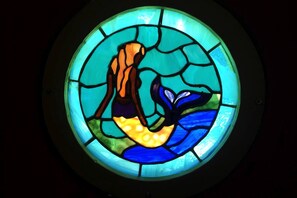 A circular stained glass window with a central figure. - Fantastic Wood Cabin Rental for the Best Nova Scotia Glamping Trip (Baddeck)