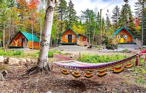 A row of cabins with a hammock in the foreground.