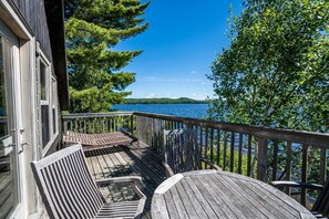 A wooden deck with a view of a lake and trees.