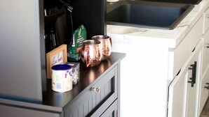 Une cuisine avec des meubles de couleur noire, un plan de travail blanc et un four à micro-ondes.