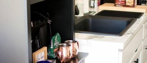 Coffee/tea maker, fridge, stovetop, cookware/dishes/utensils