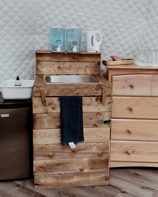 A compact kitchen with a sink, wooden cabinets, and a kettle. - Canadian Glamping Escape in Pet-Friendly Beach Dome in Dunchurch, Ontario (Dunchurch)