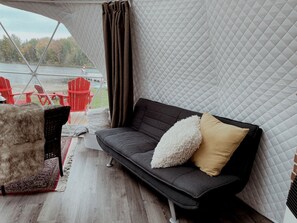 Un espace extérieur accueillant, aménagé avec un canapé, des fauteuils et un tapis.