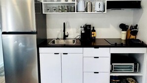 A modern kitchen with a stainless steel refrigerator, a coffee machine, and a toaster. - Peaceful Boat Retreat with Luxury Interior with Hot Tub in Cocagne, New Brunswick (Cocagne)