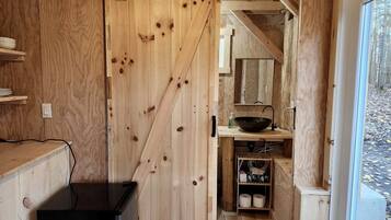 Un intérieur en bois avec une porte coulissante donnant sur un espace cuisine.