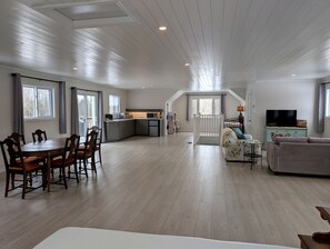 A spacious living area with a dining table, kitchen, and seating area. - Aspen Acres Cabin with BBQ and Private Deck (Chatsworth)