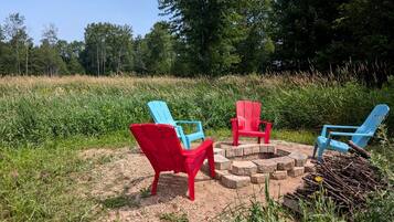 Sitzgelegenheiten im Freien mit Adirondack-Stühlen und einem Feuerkorb.