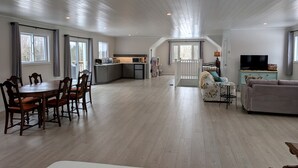 Un grand espace de vie comprenant une salle à manger, une cuisine et un coin salon.