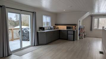 Een moderne keuken met grijze kastjes, een magnetron en een koffiezetapparaat.