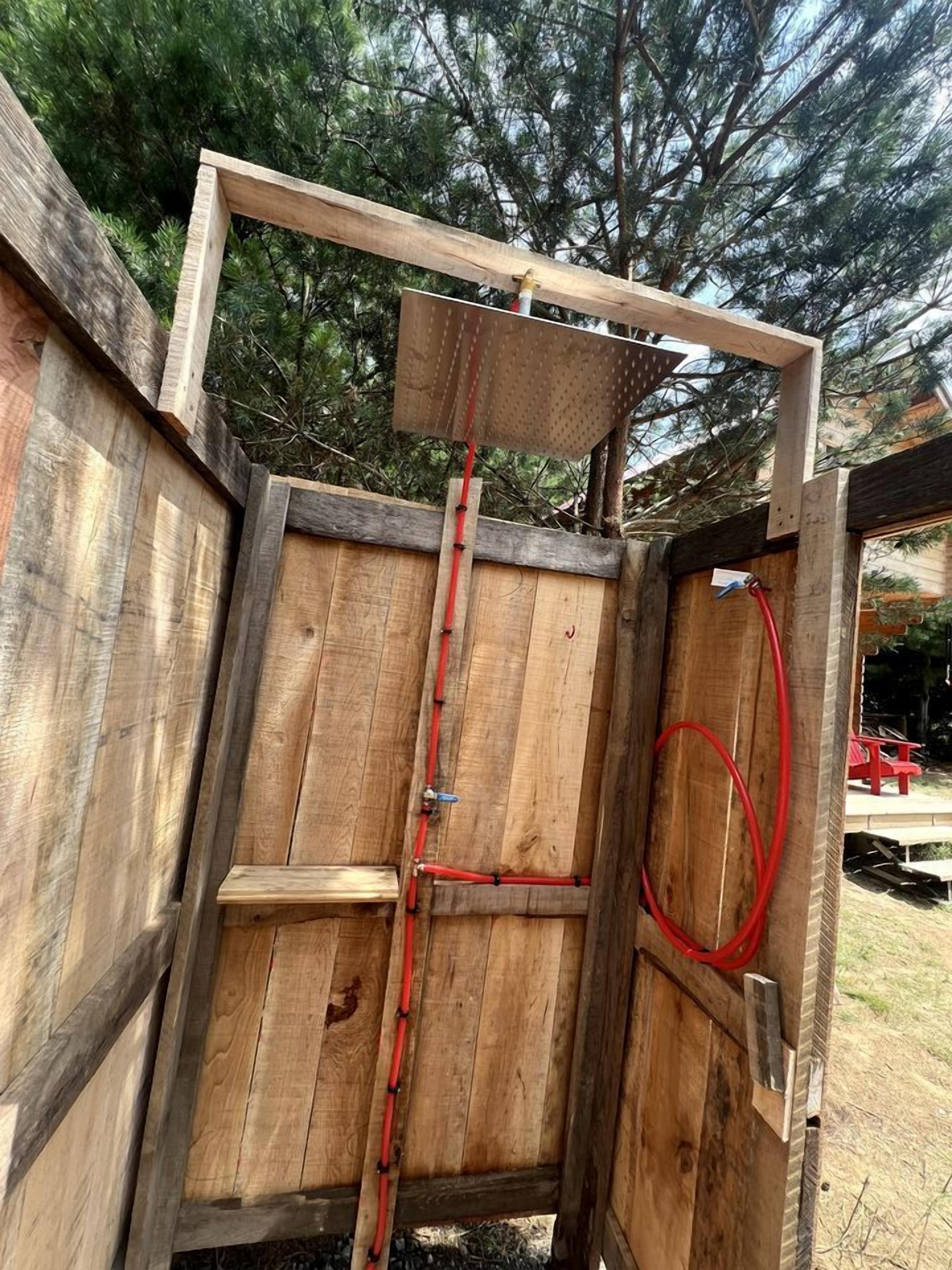 A wooden structure with a ladder, a red hose, and a metal frame.