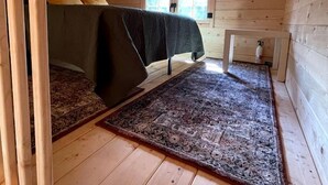 Ein gemütliches Schlafzimmer im Dachgeschoss mit einem Bett, einem kleinen Tisch und einem Fenster.
