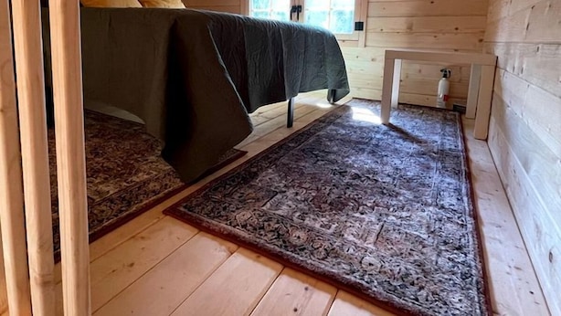 Quarto de sótão acolhedor com cama, uma mesa pequena e uma janela.