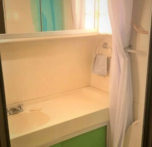 Ein Badezimmer mit Waschbecken, Spiegel und Handtuchhalter.