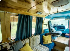 Un intérieur chaleureux avec un canapé, des coussins, un volant et une fenêtre.