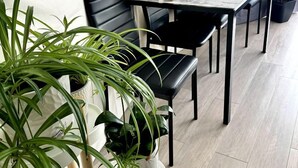 Un espace repas comprenant une table, des chaises et des plantes en pot.