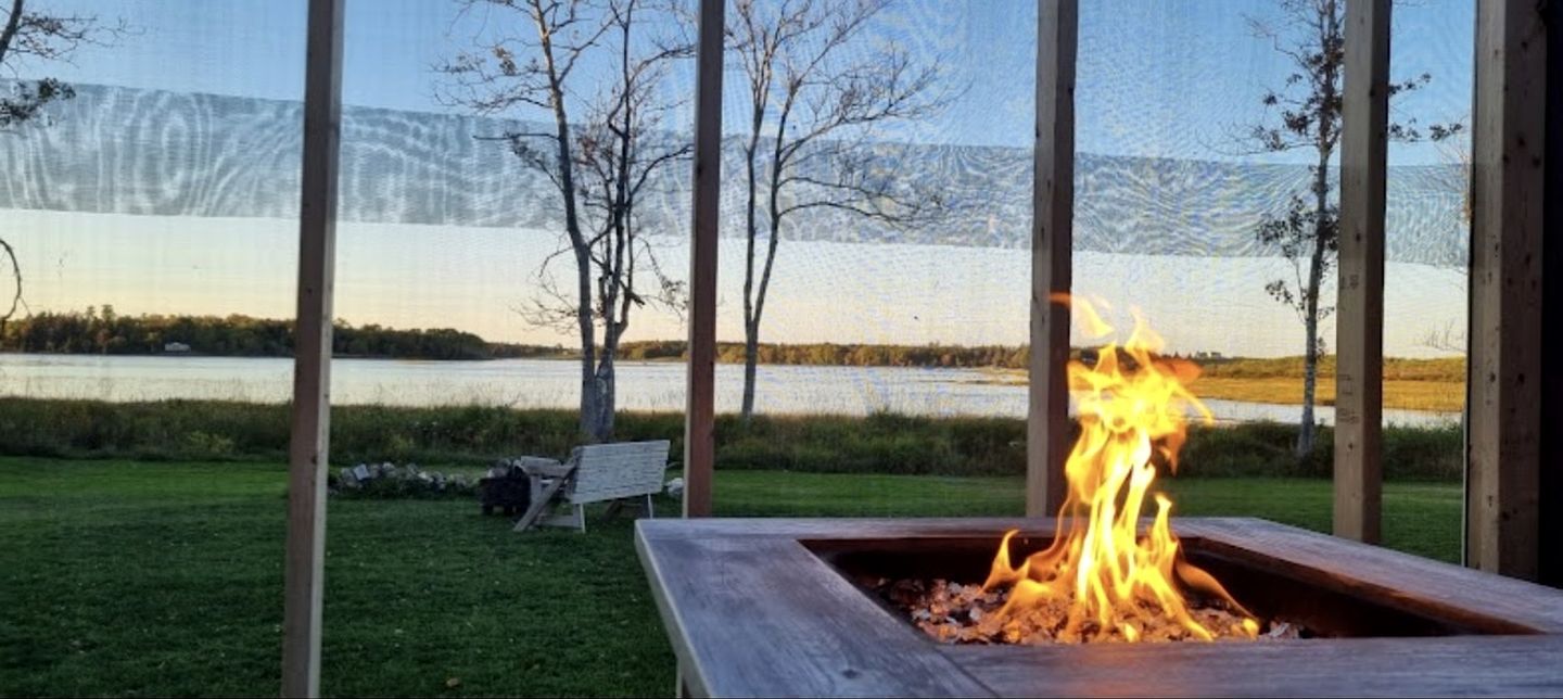 A fire pit with a view of a lake and mountains.