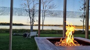 A fire pit with a view of a lake and mountains.
