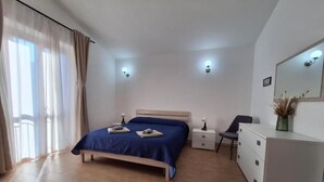 Une chambre à coucher avec un lit, des tables de chevet, une commode et un miroir au mur.