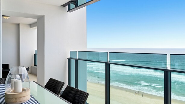 A balcony with a glass railing overlooking a beach. - Soul Surfers Paradise - Lvl11 Ocean View - Apartment (Surfers Paradise)
