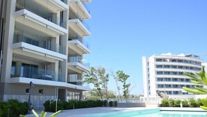 A modern multi-story hotel with balconies, a swimming pool, and a clear sky. - SE207 - Stunning Two-Room Apartment Overlooking the Sea (Senigallia)