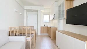 A compact living space with a kitchenette, a dining area, and a TV mounted on the wall. - SE207 - Stunning Two-Room Apartment Overlooking the Sea (Senigallia)