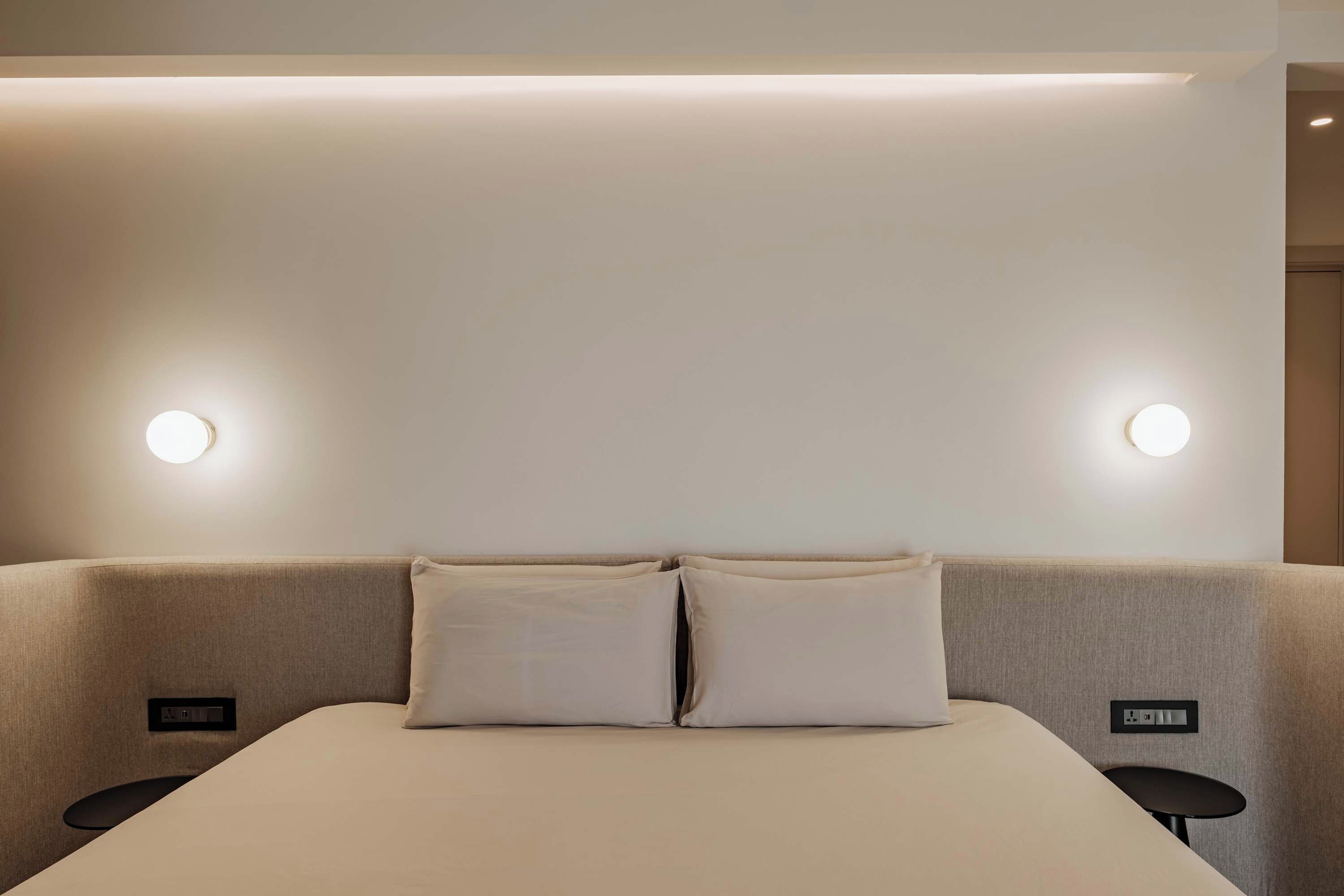 Ein Hotelzimmer mit einem Bett, zwei Nachttischen und Wandleuchten.