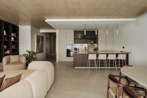 A modern kitchen with a central island, bar stools, and a dining table. - High-floor views, hot tub & sauna | AZ13 (Sliema)