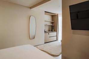 A modern bedroom with a bed, a large mirror, a wardrobe, and a TV. - High-floor views, hot tub & sauna | AZ13 (Sliema)