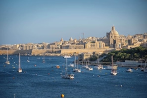 A coastal cityscape with a prominent historical building and a marina filled with boats. - High-floor design, hot tub & sauna | AZ14 (Sliema)