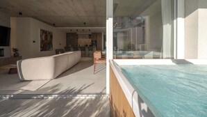 A modern interior with a large living area, a kitchen, and a glass-enclosed hot tub. - Valletta views, hot tub, sauna, ferries | AZ12 (Sliema)