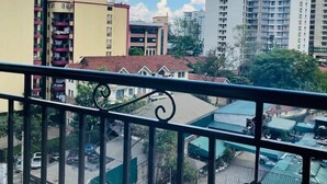 A balcony with a view of a residential area, including multi-story buildings and a green sports court. - Cobot Suites Marcus Garden (Nairobi)