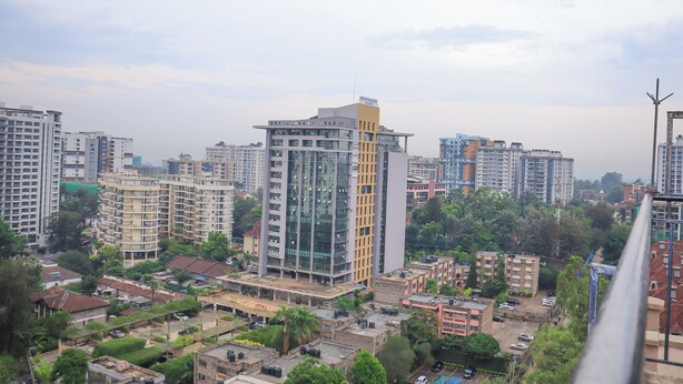 A high-rise building with a modern glass facade and a yellow accent on the side. - Cobot Suites Marcus Garden (Nairobi)