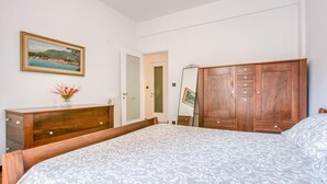 A bedroom with a bed, wooden dresser, and a mirror. - Lovely apartment in Rapallo with WiFi (Rapallo)