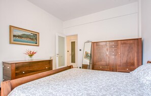 A bedroom with a bed, wooden dresser, and a mirror. - Lovely apartment in Rapallo with WiFi (Rapallo)
