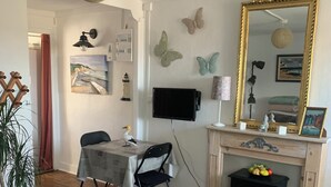 Una sala de estar acogedora con comedor, chimenea y un espejo grande.