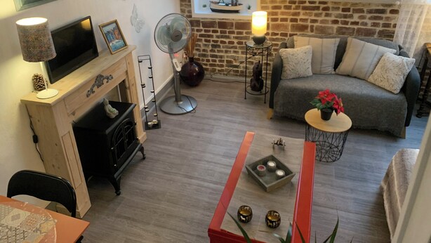 Una sala acogedora con chimenea, sofá, mesa de comedor y televisor.