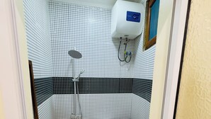 Un baño pequeño con inodoro, lavamanos y ducha.