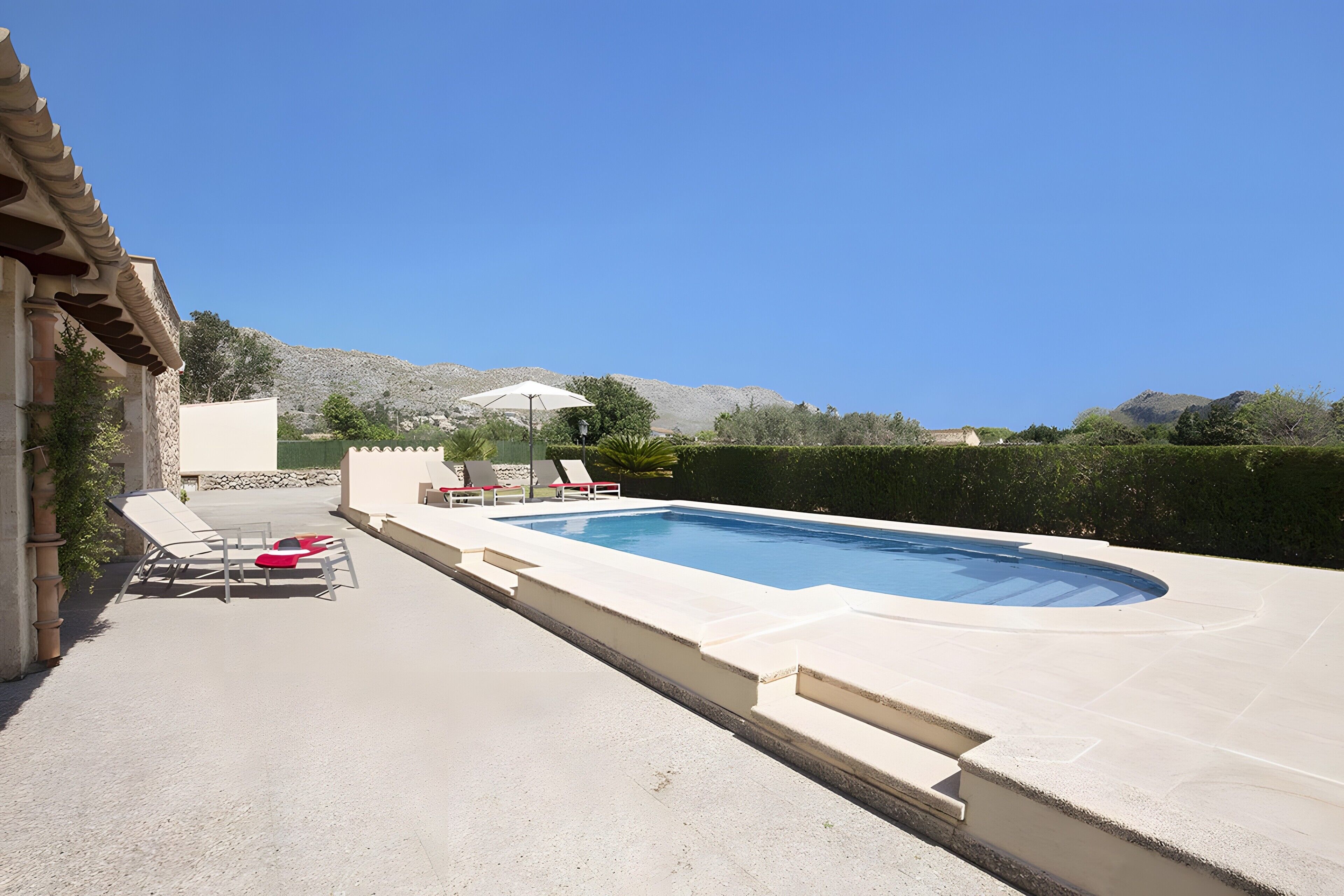 A swimming pool with lounge chairs and a view of mountains.