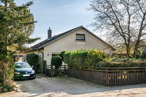 Ein zweistöckiges Haus mit Ziegelaußenwand, einem gepflasterten Auffahrt und einem Holzzaun.
