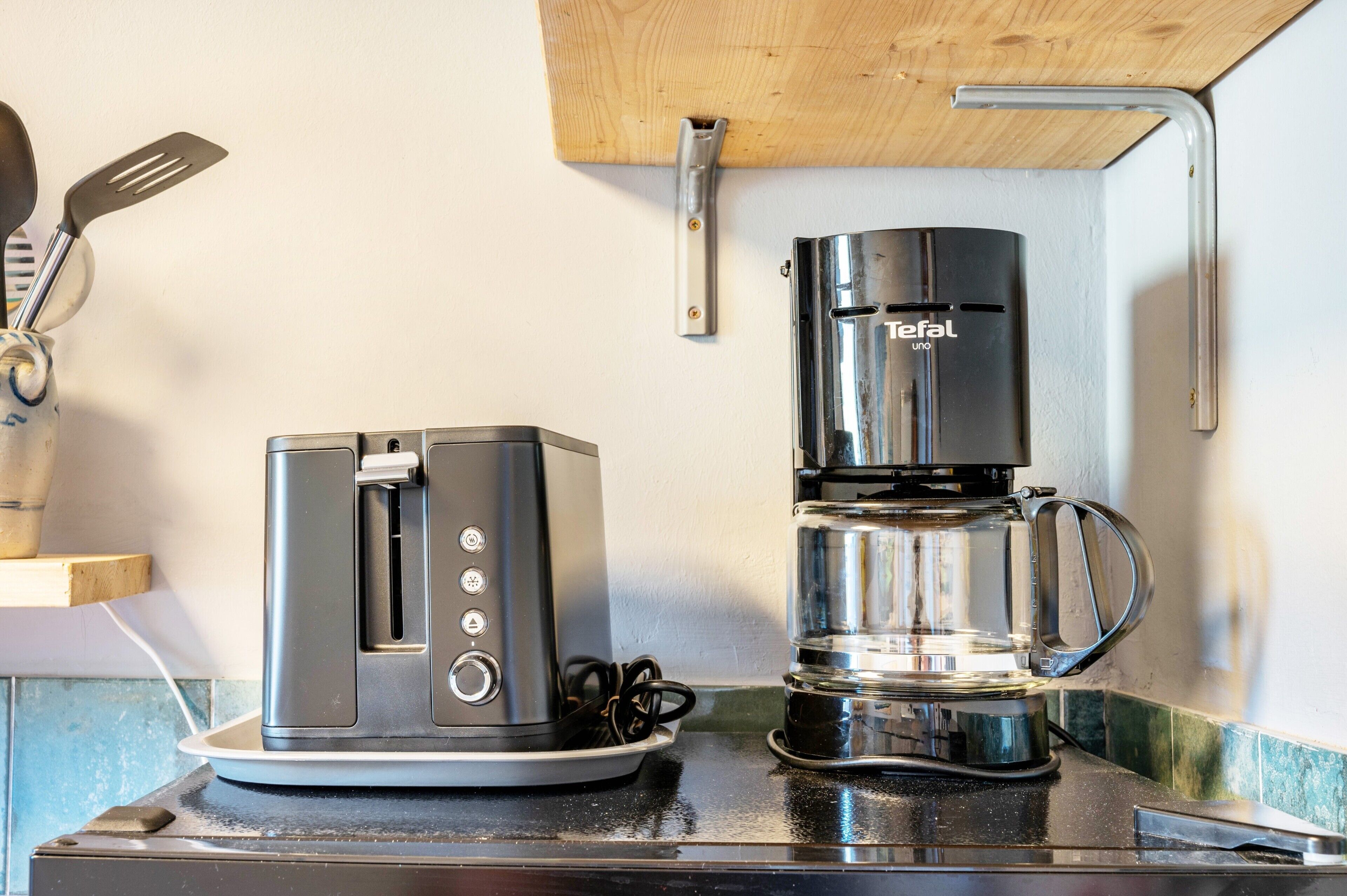 A kitchen with a toaster and a coffee maker on the counter.