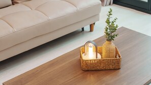 A wicker basket with a candle holder and a small plant on a wooden table. - Yeosu The Haru Ocean View Pension (Yeosu)