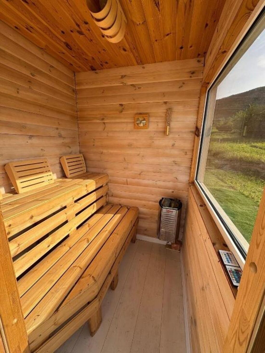 A wooden cabin with a bench and a window.