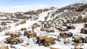 A snow-covered village with traditional wooden houses, a winding road, and mountains in the background. - Cozy home in Rauland with sauna (Rauland)