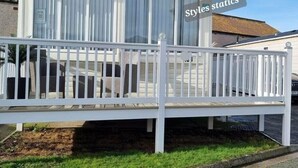 Un bâtiment moderne doté d’un patio couvert, d’une clôture blanche et d’une enseigne sur laquelle on peut lire « Styles statics ».
