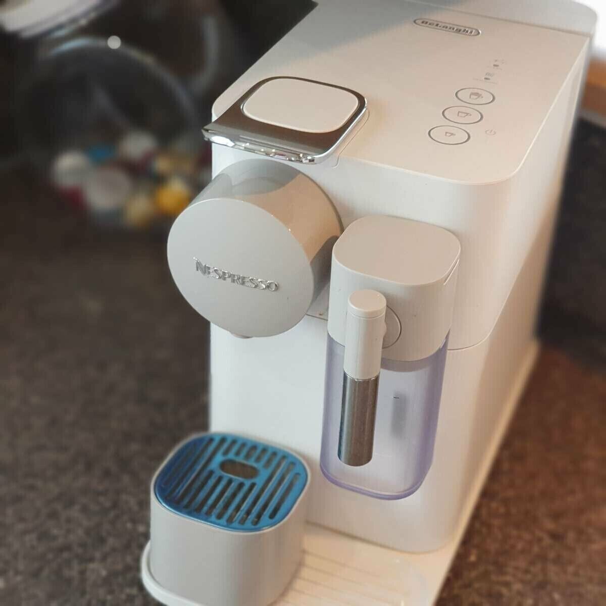 Una cafetera con un depósito para cápsulas individuales y un tanque de agua.